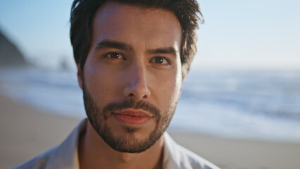 Portrait handsome bearded guy standing on seashore. Man looking confidently