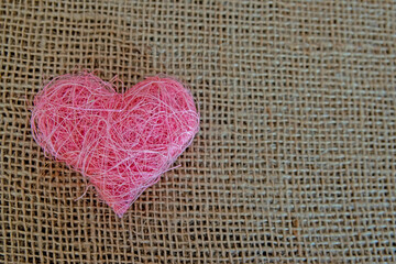 Pink fabric heart shape on the natural background.