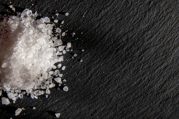  White salt cristals for food on the black background.
