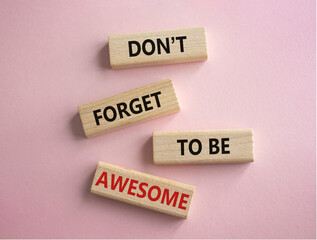 Do not forget to be Awesome symbol. Concept word Do not forget to be Awesome on wooden blocks. Beautiful pink background. Motivation concept. Copy space