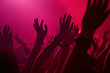 concert guests raise their hands to give a standing ovation at concert
