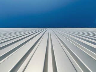 View upwards to the facade of a warehouse with a cladding of silver corrugated aluminum...