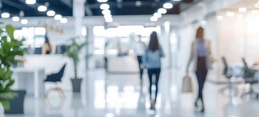 Fototapeta premium Blurred image of people in a mall. A nondescript, blurry photo capturing the hustle and bustle of individuals walking in a modern shopping mall, with bokeh lights