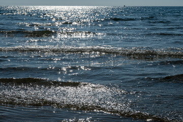 Crystal clear sea water texture with glare from the sun, wallpaper