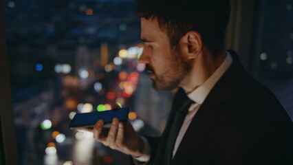 Aggressive manager yelling phone standing office at night close up. Mad ceo call