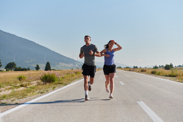 Energized by the beauty of nature, a couple powers through their morning run, their bodies and...
