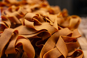 Italian food, dried handmade colorful pasta pappardelle with saffron, ready to cook, Milan, Lombardy, Italy