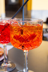 Aperol and Campari Spritz orange bitter long drink cocktails made with liqueur, prosecco sparkling wine, ice cubes and piece of orange, Milan, Italy