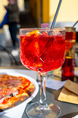 Spritz Campari red bitter long drink cocktail maid with liqueur, prosecco sparkling wine, ice cubes and piece orange, Milan, Italy