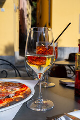 Glass of cold dry white wine served outdoor in cafe in Bellagio, Como lake, Italy