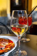 Glass of cold dry white wine served outdoor in cafe in Bellagio, Como lake, Italy