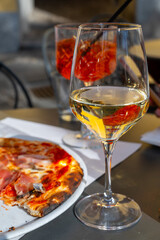 Glass of cold dry white wine served outdoor in cafe in Bellagio, Como lake, Italy