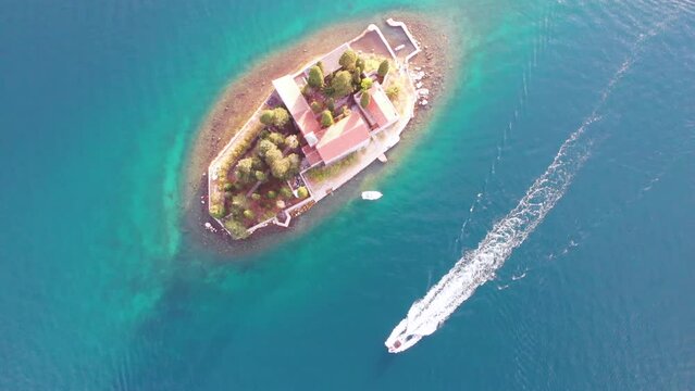 Aerial drone view of small island in the sea with church Lady of the Tickle church or Gospa od Skrpjela in Perast, Montenegro.