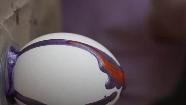 Boy at home in the kitchen painting Easter eggs. Close-up. Purple eggs