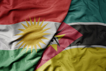 big waving national colorful flag of mozambique and national flag of kurdistan.