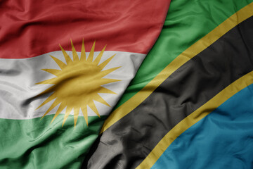 big waving national colorful flag of tanzania and national flag of kurdistan.