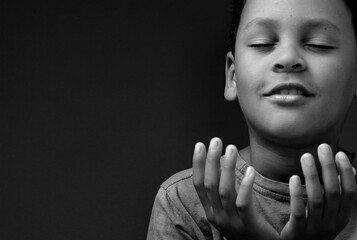 boy praying to god with hands together on grey background stock photo	