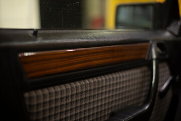 Wooden trim in the interior of the car. Wooden panel on the door. Fabric Upholstery Machine Door.