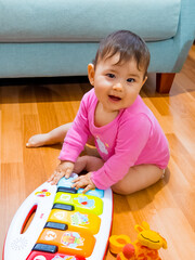 Linda bebe jugando con su piano en el piso