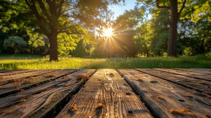 The warm glow of a sunny afternoon illuminates an empty wooden table, with a backdrop of a peaceful park scene, the distant trees and clear blue sky providing - obrazy, fototapety, plakaty
