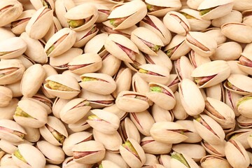 Tasty unpeeled pistachios as background, top view