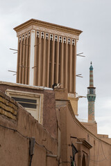 A ventilation tower or windcatcher,  constructed with adobes and a minaret of a mosque in the old...