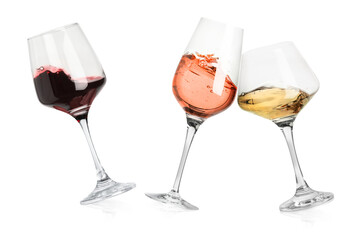 Different types of wine splashing in glasses on white background
