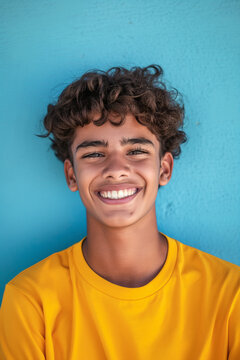 Realistic photo, teenager, boy, brasilian, 16 years old, smiling, in casual clothes in blue and yellow tones, Royal color palette is blue, small shades of blue, white and yellow studio light