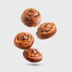 Foto op Aluminium Sweet buns. Delicious rolls with raisins falling on light grey background © New Africa
