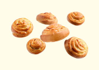 Fototapeta premium Sweet buns. Delicious rolls with raisins falling on beige background