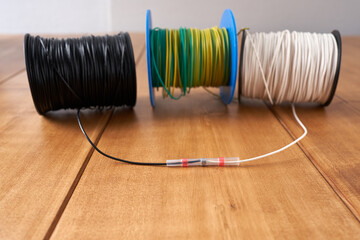 Copper wire coil with different lines on the wooden table.