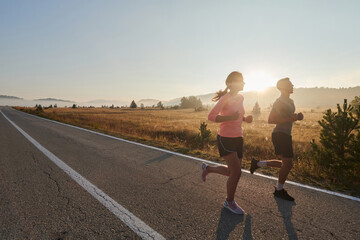 Energized by the beauty of nature, a couple powers through their morning run, their bodies and...