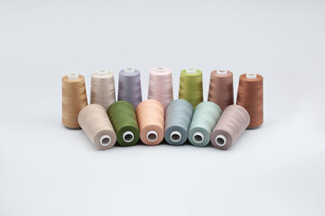 Thread spools background. Various colors sewing kit. Collection of threads. Pale pastel colors. Sew threads. Colorful hobby background. Tailor shop texture. Isolated on white.