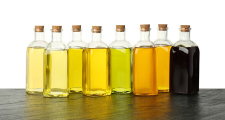 Vegetable fats. Bottles of different cooking oils on wooden table against white background