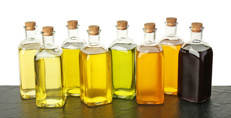 Vegetable fats. Bottles of different cooking oils on wooden table against white background