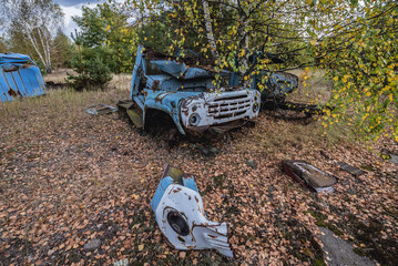 Old car on wrecking yard near Illinci village in Chernobyl Exclusion Zone in Ukraine - obrazy, fototapety, plakaty