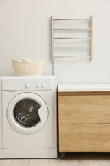 Stylish bathroom interior with heated towel rail and washing machine