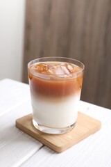 Glass of iced coffee on white wooden table