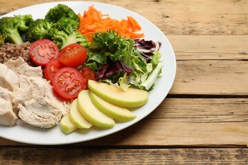 Balanced diet and healthy foods. Plate with different delicious products on wooden table, space for text