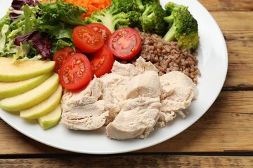 Balanced diet and healthy foods. Plate with different delicious products on wooden table