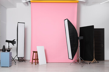 Pink photo background, stool and professional lighting equipment in studio - obrazy, fototapety, plakaty