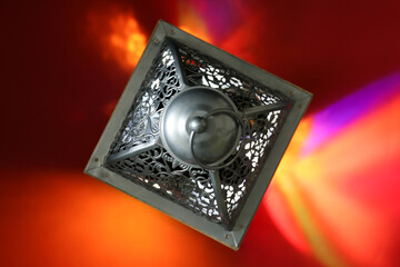 Decorative Arabic lantern on red background, top view