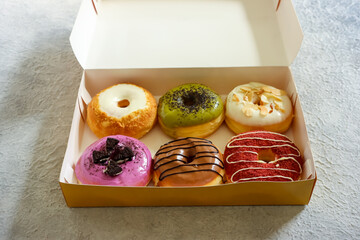 Assorted donuts in paper box, looks sweet and delicious