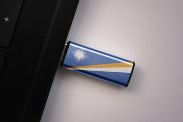 usb flash drive in notebook computer with the national flag of Marshall Islands on gray background.