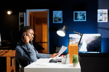 African american man calling investors to obtain new funds for capital investment, working from...