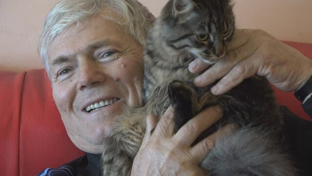 Portrait of elderly man caressing his cat