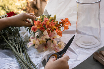 A person is cutting stems from a flower with scissors