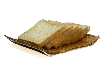 Whole wheat bread slices on a bamboo tray with weaving. against a white backdrop