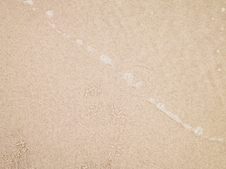 Sea water on sandy beach sand - nature background.