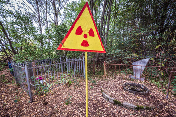 Radiation warning sign on a cemetery in Pripyat abandoned city in Chernobyl Exclusion Zone, Ukraine